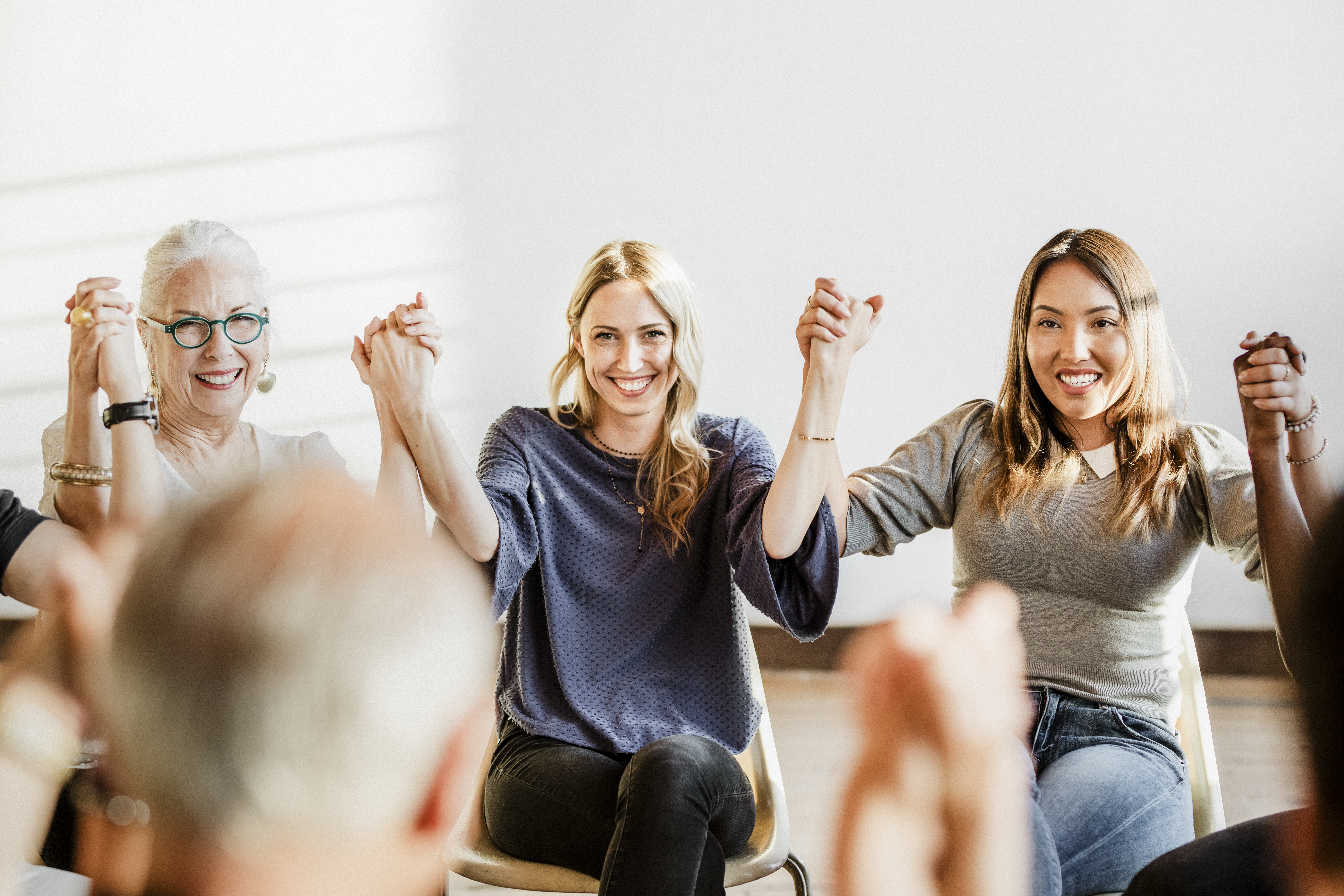 group of people holding hands and smiling