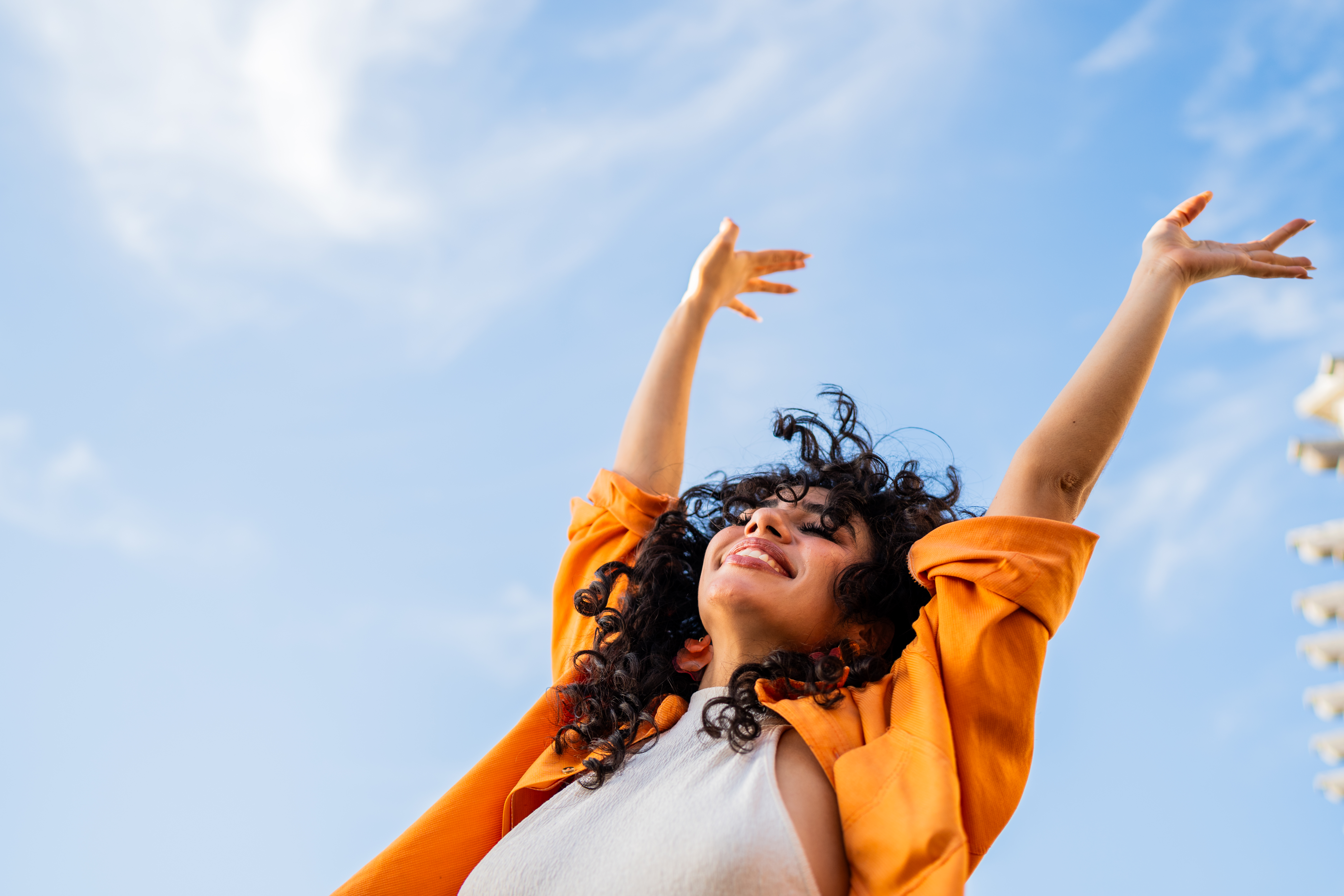 A woman smiling and throwing her hands in the air