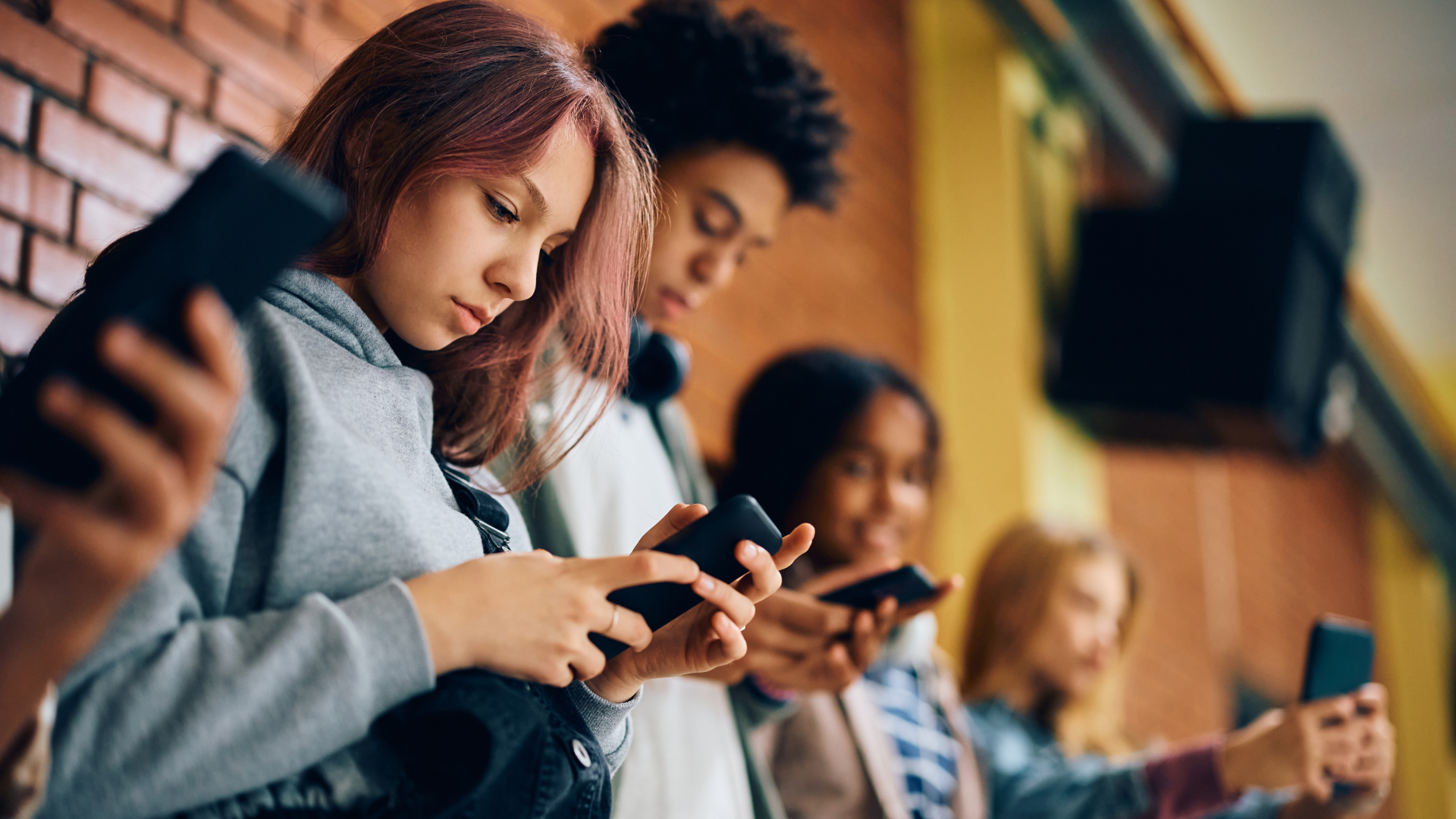 A group of teenagers looking at their smart phones